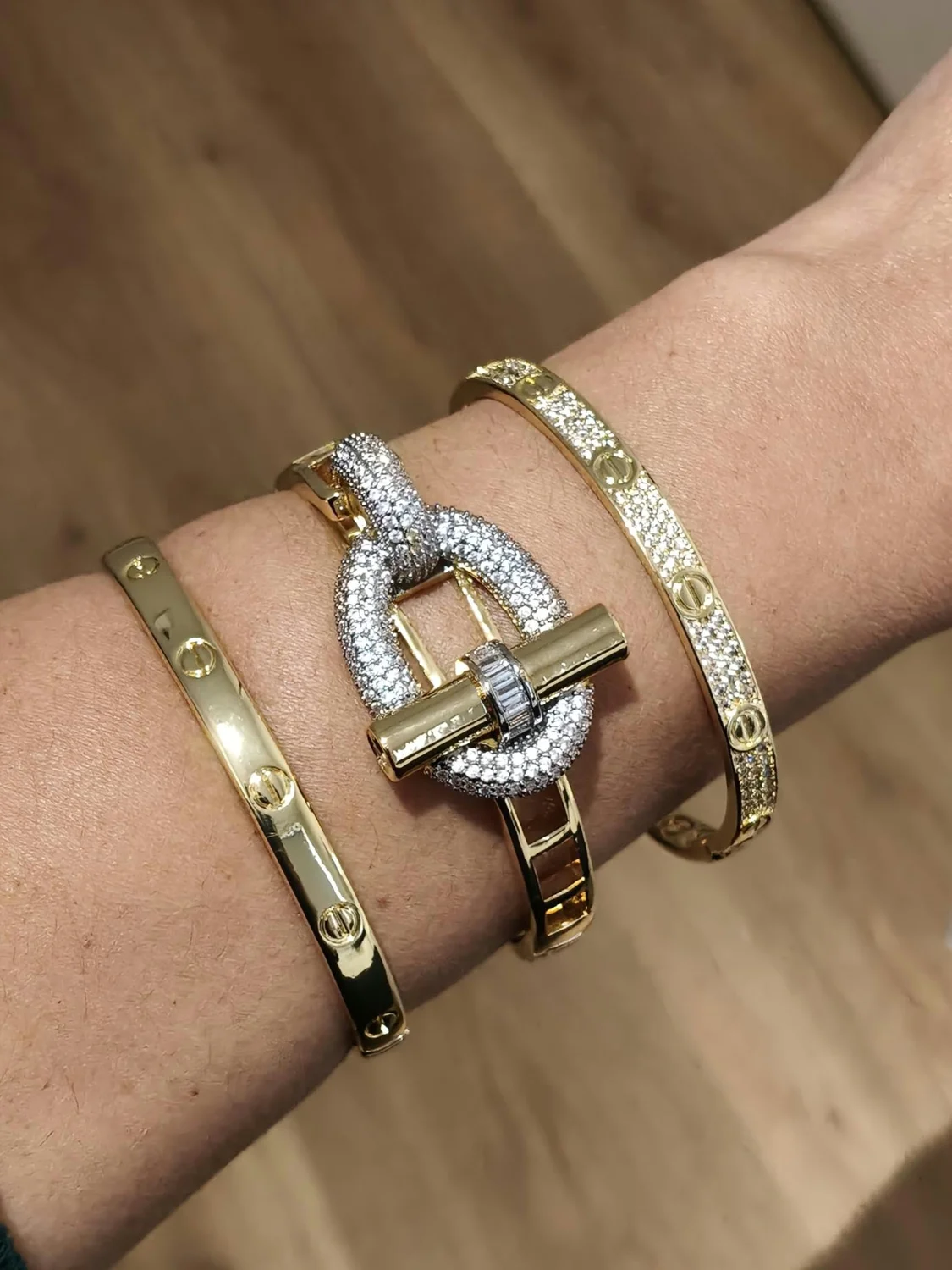 Braceletes dourados da coleção Maná usados no pulso